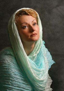 The beautiful girl in a blue scarf in studio