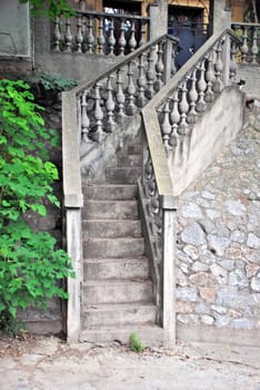 gray narrow concrete stairs over stone wall