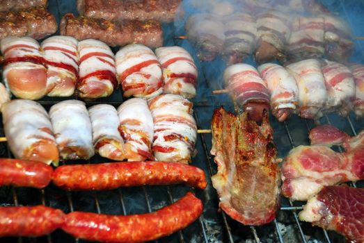 various meat grilled on barbecue in smoke