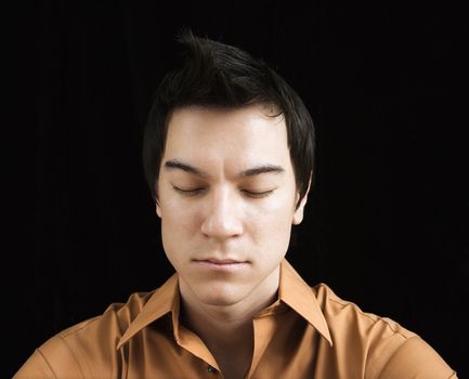 Asian young man sitting meditating.