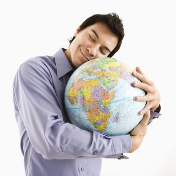 Young Asian man holding globe with happy expression on his face.