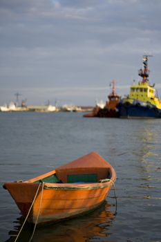 Smal boat into dock with big ships in the background