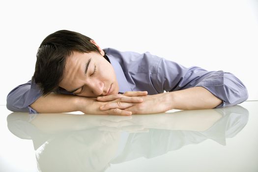 Asian businessman sleeping on desk in the office.