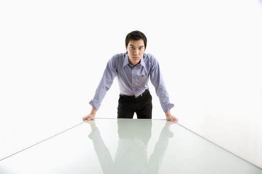 Young Asian business man standing over conference table.