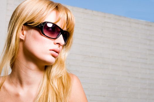 Young blond girl enjoying the sun in and around the swimming pool