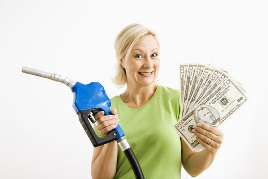 Portrait of smiling adult blonde woman holding gas nozzle and lots of money.