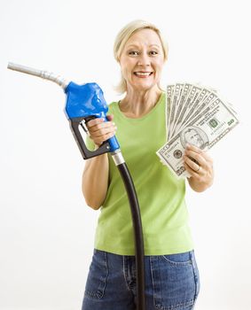 Portrait of smiling adult blonde woman holding gas nozzle and lots of money.