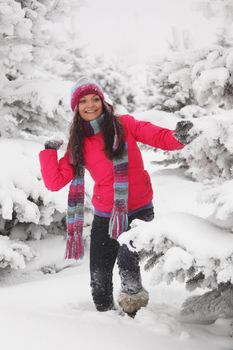 winter woman play snowballs on snow background