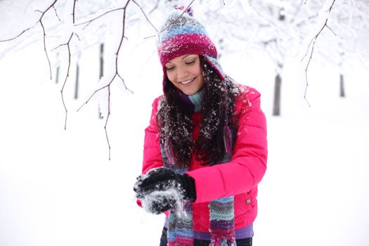 winter woman play snowballs on snow background