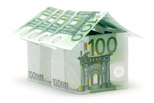 Big house built of several one hundred euro bills. Isolated on a white background.