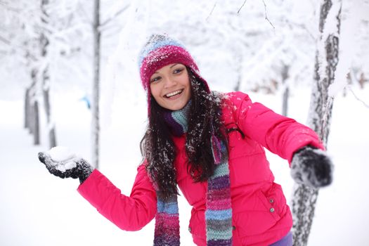 winter woman play snowballs on snow background