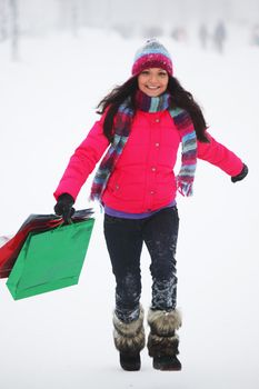 winter girl with gift bags on snow background