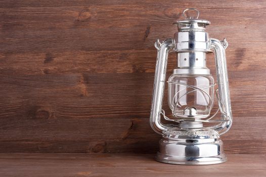 Old kerosene lantern on the dark wooden background