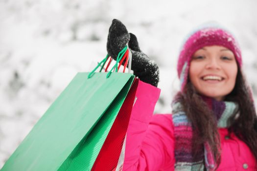 winter girl with gift bags on snow background