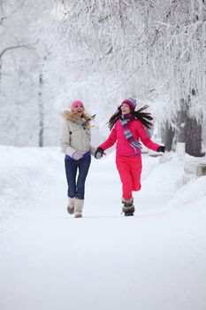 two winter women run by snow frosted alley