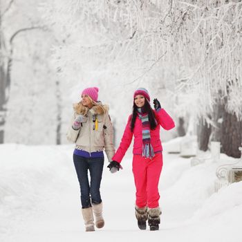 two winter women run by snow frosted alley