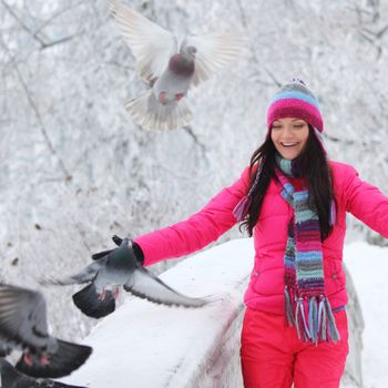 winter women give food to the pigeon