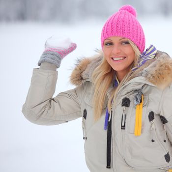 winter woman play snowballs on snow background