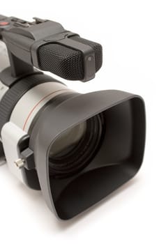 Close-up on lens and microphone of a professional camcorder. Isolated on a white background.