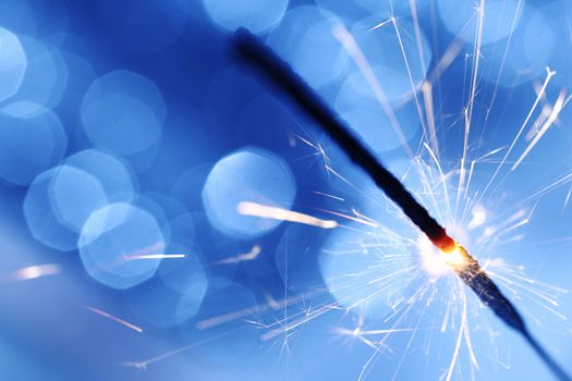 sparkler on blue bokeh background macro close up