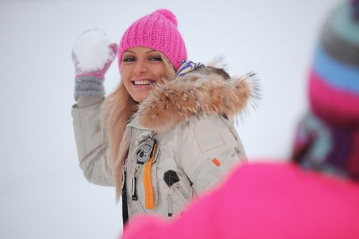 winter woman play snowballs on snow background