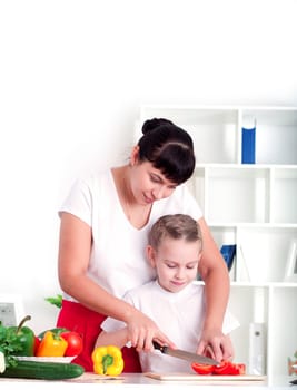 Mother and daughter cooking vegetable salad together