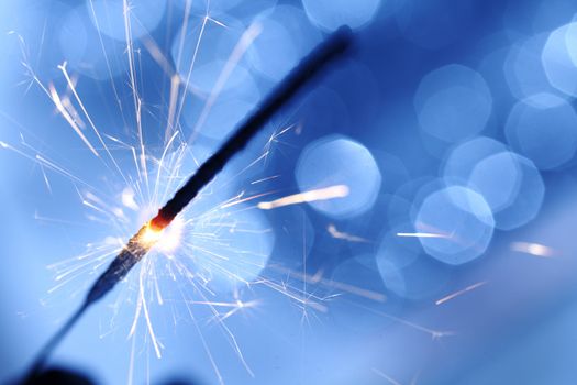 sparkler on blue bokeh background macro close up