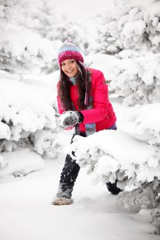 winter woman play snowballs on snow background