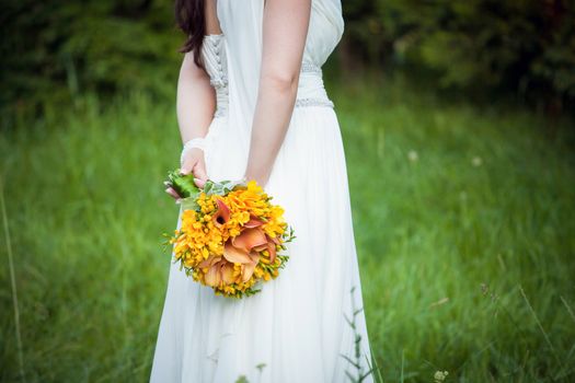 Bride holding a wedding bouquet in nature