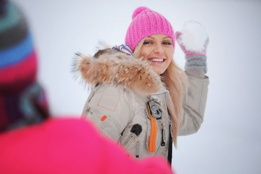 winter woman play snowballs on snow background