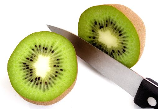 Slicing a fresh kiwi. Isolated on a white background.