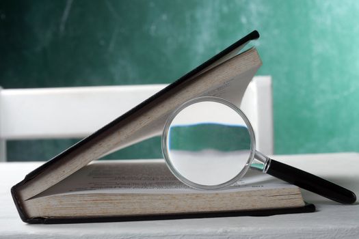 stock image of the magnifier between the pages of book