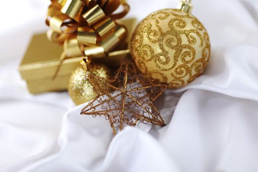  gold christmas ball on white silk