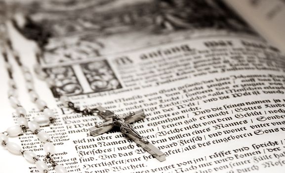 Rosary with crucifix on an old bible.