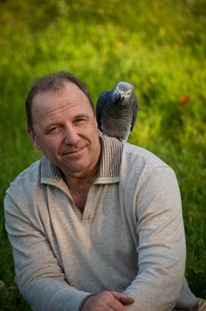 Portrait of  man with a gray parrot Jaco.