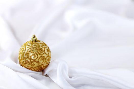  gold christmas ball on white silk