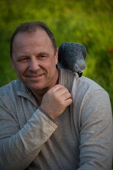Portrait of  man with a gray parrot Jaco.