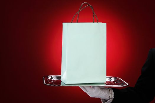 Doorman wearing white gloves, holding shopping bags