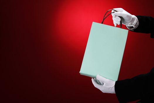 Doorman wearing white gloves, holding shopping bags