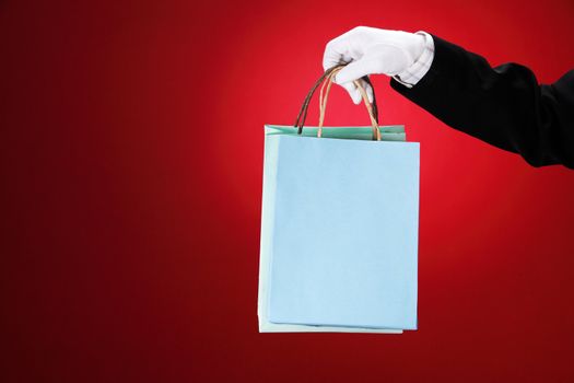 Doorman wearing white gloves, holding shopping bags