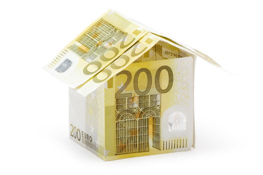 Small house built of several two hundred euro bills. Isolated on
white background.