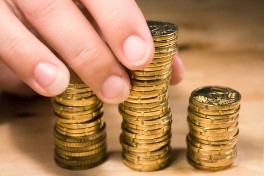 Person stacking up 20 cent coins on a table.