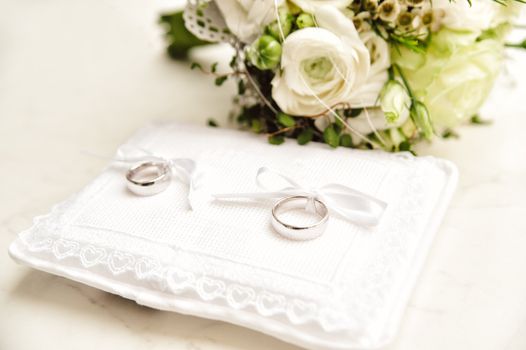 White Pad with wedding rings and bridal bouquet