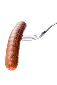 a delicious sausage on a fork over white