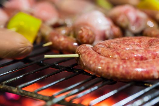 different types of meat cooking outside on a barbecue