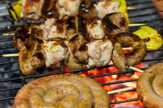 different types of meat cooking outside on a barbecue