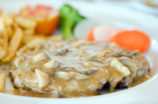 beef steak with mushrooms sauce served with french fries