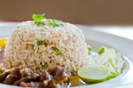 Mixed cooked rice with pork sauce , mango , chili, and fresh vegetable on white dish