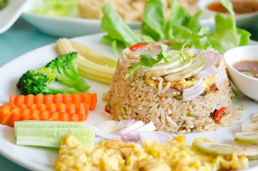 mixed cooked rice with shrimp paste sauce , fried egg and fresh vegetable.