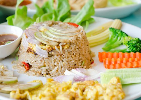 mixed cooked rice with shrimp paste sauce , fried egg and fresh vegetable. sweet and spicy